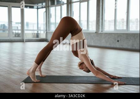 Corpo flessibile che si allunga. La donna fitness in abbigliamento sportivo è al chiuso. Foto Stock
