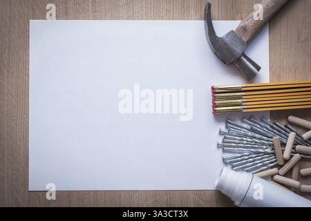 Metro di legno piani di costruzione laminati chiodi di metallo di carta bianca martello a baionetta cumulo di tasselli scanalati su pannelli di legno concetto di manutenzione dello spazio di copia Foto Stock