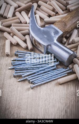 Tasselli in legno chiodi in acciaio e struttura con martello a baionetta Foto Stock