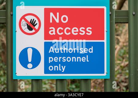 L'immagine mostra un cartello "nessun accesso, solo personale autorizzato" attaccato a una recinzione metallica verde. Il cartello è lì per limitare l'ingresso a un'area specifica, Foto Stock