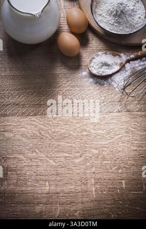 Due uova caraffa latte e sppon con farina corolla organizzata copyspace Foto Stock