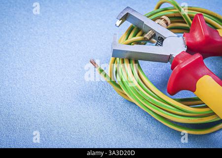 Pinza spelafili cavi elettrici su fondo blu concetto di elettricità Foto Stock