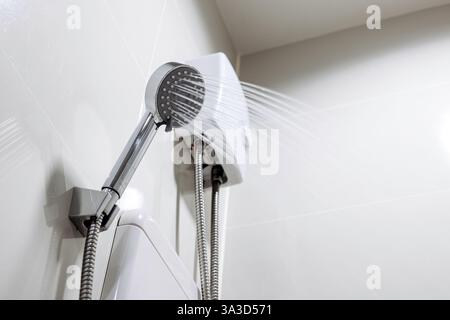 Doccia corrente con scaldabagno. Concetto di tecnologia a risparmio energetico, comfort moderno e risparmio energetico. Foto Stock