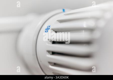 Regolatore di temperatura sul radiatore. Un concetto che enfatizza il risparmio energetico, i sistemi di riscaldamento e il comfort domestico. Ideale per alloggiamenti a basso consumo energetico Foto Stock