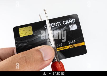 Tagliare a mano la carta di credito con le forbici per distruggerla. Foto Stock