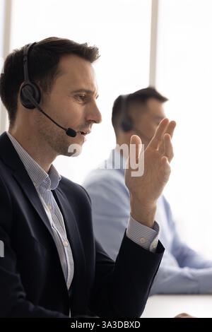 Uomo professionista di telemarketing latino che parla al cliente al telefono Foto Stock