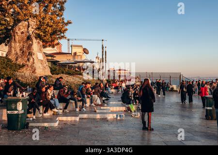 Lisbona, Portogallo - 2 gennaio 2025: Persone al Miradouro de Santa Catarina che si godono il tramonto su Lisbona Foto Stock