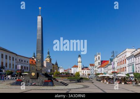 Monumento alla guerra nella piazza principale con gente che mangia e beve in un ristorante all'aperto, Banska Bystrica, Slovacchia Foto Stock