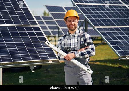Verticale, tenendo lo strumento di livellamento. Progettazione di pannelli solari fotovoltaici all'aperto di giorno. Foto Stock