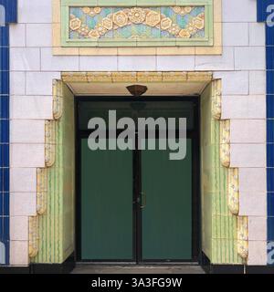 Porta ornata d'epoca incorniciata da piastrelle decorative Art Deco in tonalità di verde, blu e giallo, a Chicago. Foto Stock