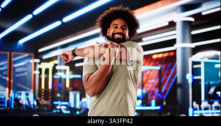 L'uomo afroamericano flessibile in palestra mostra le abilità di allenatore di fitness. Foto Stock