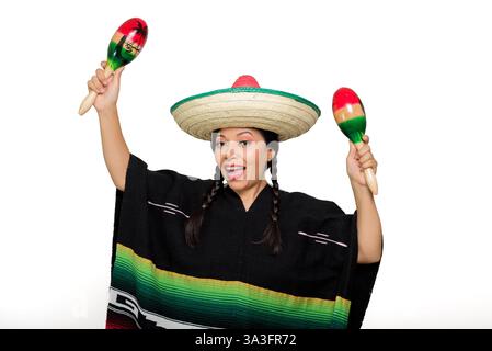 Una donna messicana sorridente che indossa un poncho colorato e un cappello gioca a maracas, isolata su sfondo bianco. Foto Stock