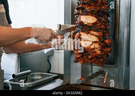 Lo chef prepara e prepara la tradizionale carne turca di Doner Kebab. Shawarma o gyros. Foto Stock