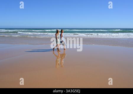 Passeggiando per la sabbia con la bassa marea, mamma e figlia si godranno un po' di benessere insieme a Surf Beach, Phillip Island (Australia) Foto Stock