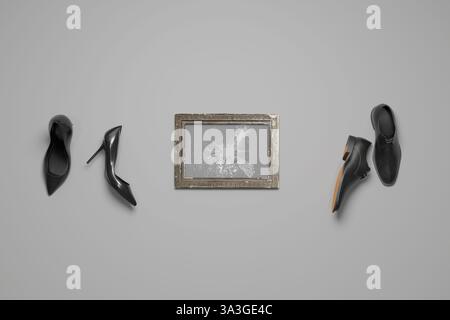 Cornice vintage con lastra di vetro rotta accanto alle scarpe da uomo e da donna. Rendering 3D. Foto Stock