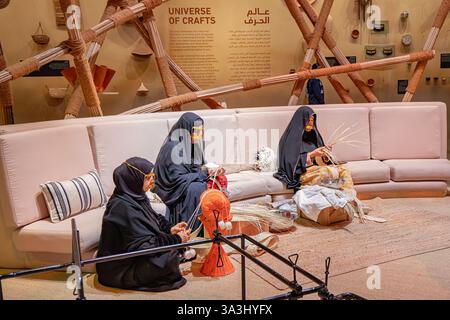 16 gennaio 2025, Abu Dhabi, Emirati Arabi Uniti: Donne che dimostrano tecniche di tessitura tradizionali in una mostra culturale Foto Stock