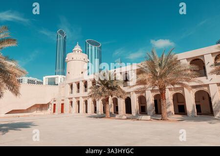 16 gennaio 2025, Abu Dhabi, Emirati Arabi Uniti: Storico forte Qasr al Hosn circondato da palme ed edifici moderni Foto Stock