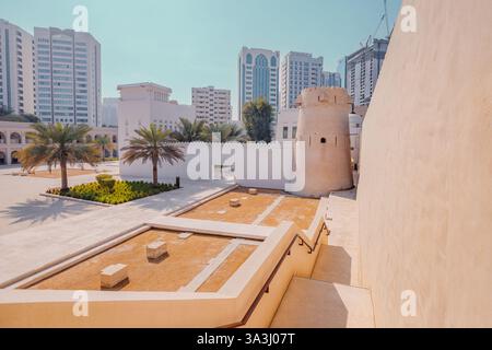 16 gennaio 2025, Abu Dhabi, Emirati Arabi Uniti: Storico forte Qasr al Hosn circondato da palme ed edifici moderni Foto Stock