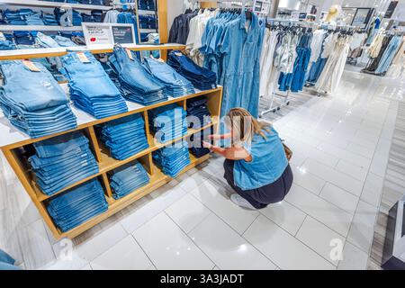 Donna che sceglie jeans Levis denim nella sezione moda dei grandi magazzini Macys. New York. STATI UNITI. Foto Stock