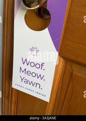 Divertente non disturbare la porta che si trova in una camera in cui sono ammessi gli animali domestici, 2024, Stati Uniti Foto Stock