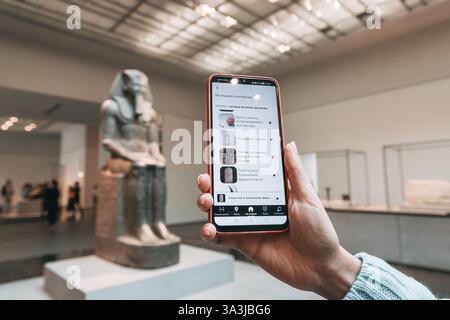 17 gennaio 2025, museo del Louvre Abu Dhabi, Emirati Arabi Uniti: Turisti che utilizzano l'applicazione per telefono cellulare per la guida virtuale mentre si godono l'esposizione Foto Stock
