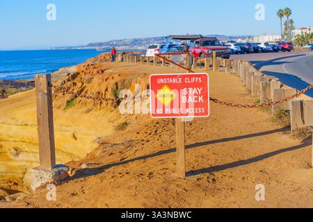 San Diego, California - 14 gennaio 2025: Vista chiara di un cartello con la scritta "Unstable Cliffs Stay Back" posizionato vicino a scogliere sabbiose che si affacciano sul oc Foto Stock