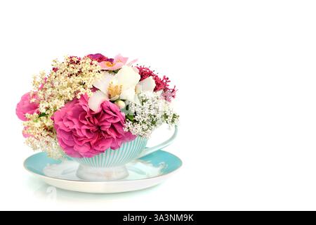Fiori estivi in una lussuosa tazza da tè su sfondo bianco. Surreale naturale alternativa erboristica di bellezza della natura in un tè. Foto Stock