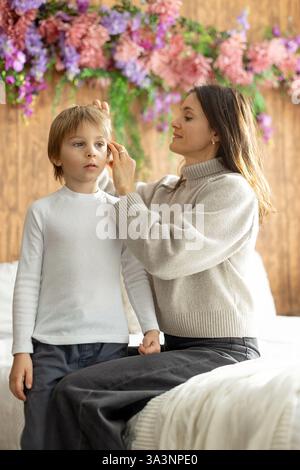 Madre, controllare i capelli dei suoi figli per i pidocchi, precauzioni prevenzione dei capelli dei bambini Foto Stock