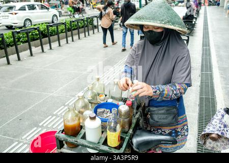 Venditore ambulante che prepara sapientemente la medicina a base di erbe in via malioboro a yogyakarta, indonesia, mostrando pratiche tradizionali e cultura locale Foto Stock