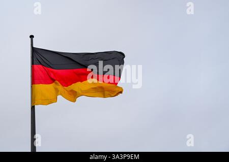 Bandiera della Germania che sventola contro il cielo sull'asta Foto Stock