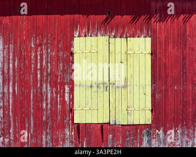 un cancello di legno verde su un muro di fienile rosso Foto Stock