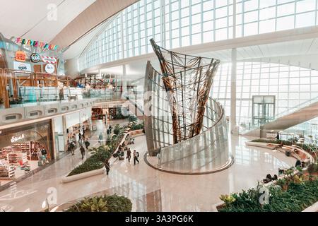 23 gennaio 2025, Abu Dhabi, Emirati Arabi Uniti: Vista dall'alto di un moderno terminal aeroportuale con passeggeri che camminano, fanno shopping e si rilassano Foto Stock