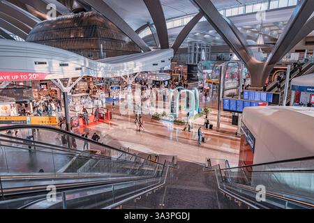 23 gennaio 2025, Abu Dhabi, Emirati Arabi Uniti: Passeggeri e personale dell'aeroporto si spostano all'interno del moderno terminal dell'aeroporto internazionale AUH Foto Stock