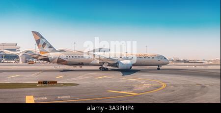 23 gennaio 2025, Abu Dhabi, Emirati Arabi Uniti: Aereo Etihad in rullaggio sulla pista dell'aeroporto AUH, pronto per la partenza sotto un cielo azzurro Foto Stock