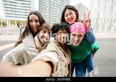 Un giovane gruppo di amici diversi che fanno un selfie insieme per strada Foto Stock