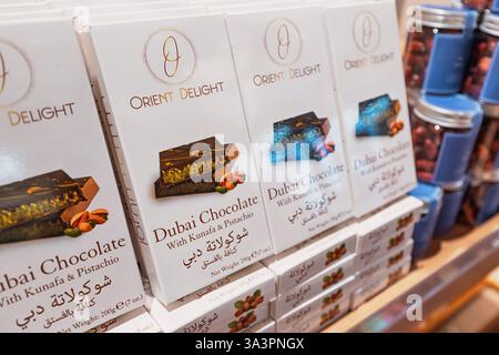 23 gennaio 2025, Abu Dhabi, Emirati Arabi Uniti: Barrette di cioccolato di Dubai con ripieno di kunafa e pistacchio impilate sullo scaffale del negozio, pronte per l'acquisto Foto Stock
