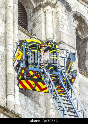 Due pompieri sulla cima di una scala girevole estesa che ispeziona lavori in pietra in un edificio alto - Tours, Indre-et-Loire (37), Francia. Foto Stock