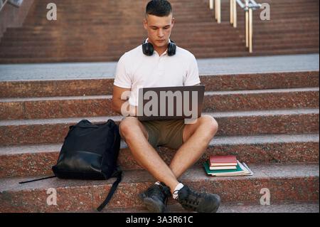 In abiti casual. Un giovane studente maschile è all'aperto. Foto Stock