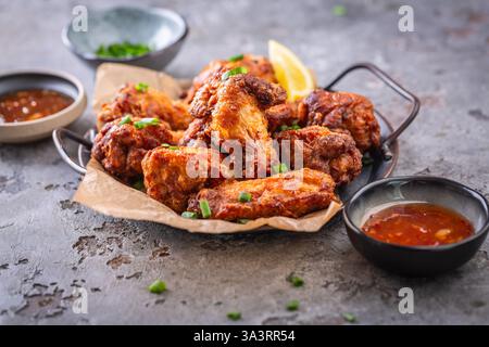 Ali di pollo tailandese speziate con salsa calda e cipolle verdi Foto Stock