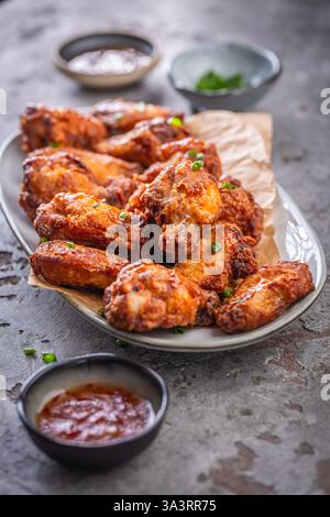Ali di pollo tailandese speziate con salsa calda e cipolle verdi Foto Stock