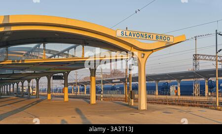 Slavonski Brod, Croazia - 22 ottobre 2024: Cartello della città presso la piattaforma principale della stazione ferroviaria Sunny Fall Morning. Foto Stock