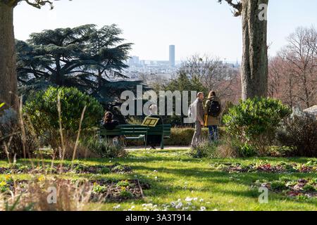 I visitatori apprezzano la bellezza serena del cimitero Pere Lachaise mentre ammirano il lontano skyline di Parigi in una giornata di sole Foto Stock