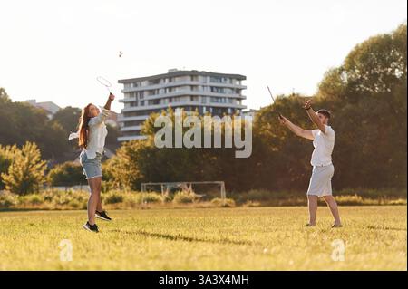 Vista laterale. L'uomo con donna gioca a badminton sul campo. Foto Stock