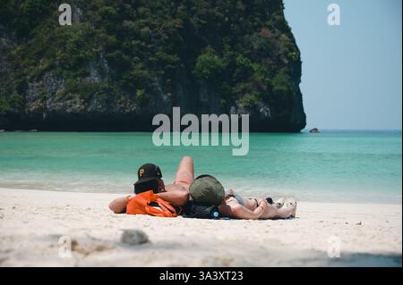 Una giovane coppia si rilassa sulle sabbie bianche di Maya Bay Foto Stock