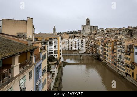 Girona, vista sul fiume Onyar con le case sospese sulle rive e la Cattedrale sullo sfondo, durante una fredda giornata invernale. Foto Stock