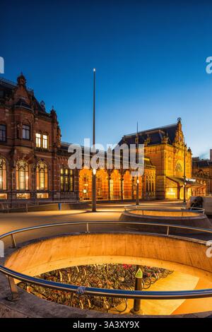 La piazza centrale di fronte alla stazione centrale della città di Groninga nei Paesi Bassi di notte con luci accese. Foto Stock