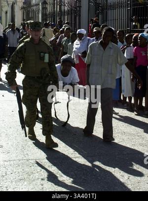 27 marzo 2004; Port-Au-Prince, Haiti; Marines della compagnia Lima, 3° battaglione, 8° reggimento di marina, sono assistiti nel spostare un uomo ferito al sito di soccorso durante un esercizio di capacità medica qui marzo 27. Foto Stock