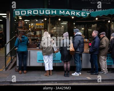 Gente in fila in una bancarella di cibo a Londons Borough Market, Inghilterra. Foto Stock