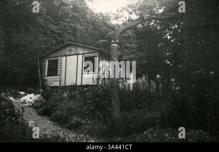 18 feb 2014 - LIECHTENSTEIN â€“ CIRCA anni '1940: Una foto antica dell'uomo guarda fuori dalla finestra di una piccola casa nel bosco (immagine di credito: © Igor Golovniov/ZUMA Wire/ZUMAPRESS.com) Foto Stock