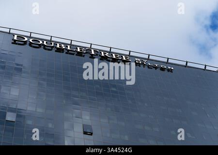 Vista di un cartello fuori dall'hotel Doubletree by Hilton. Logo sulla facciata dell'edificio dell'hotel. Minsk, Bielorussia - 4 marzo 2025 Foto Stock